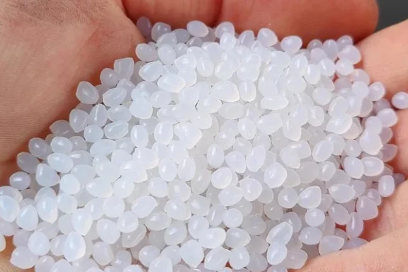 weißes Kunststoffrecyclat auf einer Hand